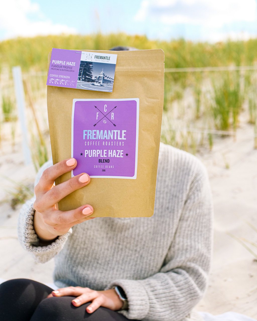 Beach portrait with product in hand